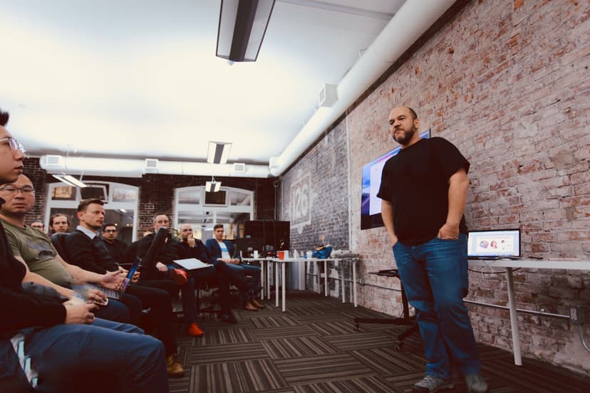 Taric speaking to a team in a modern office environment